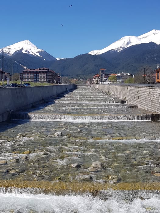 Photo of Todorka peak with sun on and the Glazne River gushing on a sunny spring day